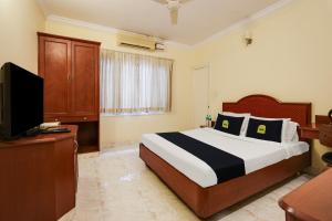 um quarto de hotel com uma cama e uma televisão em Super Collection O G Silver Polonest em Bangalore