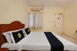um quarto com uma cama grande e almofadas pretas e brancas em Super Collection O G Silver Polonest em Bangalore