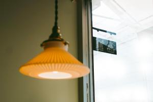 ein orangefarbenes Licht, das vor einem Fenster hängt in der Unterkunft Sumida Nagaya in Tokio