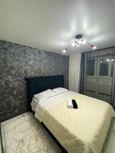 Schlafzimmer mit einem großen Bett und einem Deckenventilator in der Unterkunft Трёхкомнатные апартаменты in Öskemen