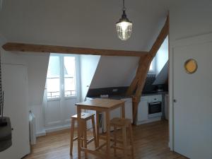 een keuken met een houten tafel en stoelen in een kamer bij Le Repaire de l'Armateur in Granville