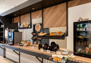 a bakery with a counter with bread and pastries at B&B HOTEL Saint-Nazaire Pornichet in Saint-Nazaire