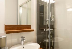 a bathroom with a sink and a glass shower at B&B HOTEL Saint-Nazaire Pornichet in Saint-Nazaire