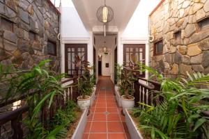 um corredor com plantas e uma parede de pedra em Hoianese Heritage Hotel - Truly Hoi An em Hoi An