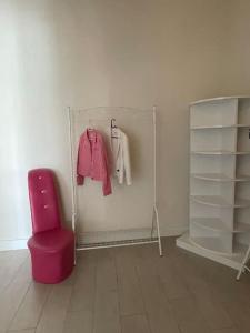 Habitación con silla rosa y estante en Fully furnished , luxury, site with Pool, en Ankara