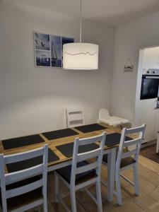 a dining room table with two chairs and a white wall at Ferienhaus 1260 in Tossens in Butjadingen OT Tossens