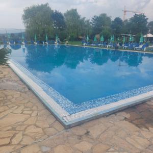 una gran piscina con sillas y agua azul en Комплекс Александьр между Банско и село Бяня, en Bansko