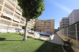 a park with benches and a tree in front of a building at DIFFERENTFLATS Aquario in La Pineda