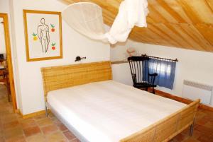 Un pequeño dormitorio con una cama y una silla. en La Sapinière, en Uzès
