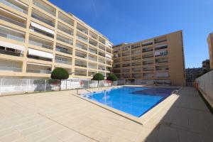 a swimming pool in front of a large building at DIFFERENTFLATS Aquario in La Pineda