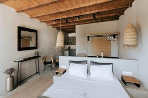 a bedroom with a white bed and a table at White and Grey 2 in Mikonos