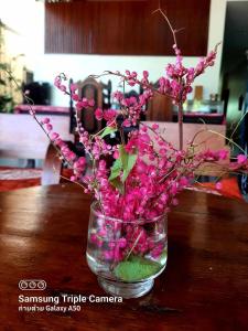 un jarrón lleno de flores rosas en una mesa en DE ROSE Hotel Chiang Mai en Chiang Mai