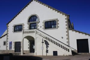 a white building with windows and an archway at Ostal - Auberge de jeunesse Concarneau in Concarneau