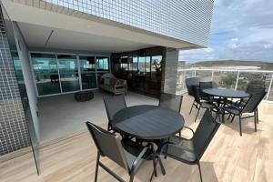 d'une terrasse avec des tables et des chaises sur un balcon. dans l'établissement Studios Premium RN, à Maceió