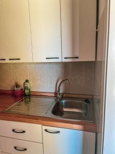 a kitchen with a sink and white cabinets at VILLAGGIO ANDORA COLOMBO in Marina dʼAndora