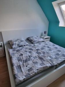 a bed with a comforter and pillows in a bedroom at Ferienhaus 1260 in Tossens in Butjadingen OT Tossens