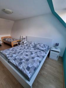 a bedroom with a bed with a blue and white comforter at Ferienhaus 1260 in Tossens in Butjadingen OT Tossens
