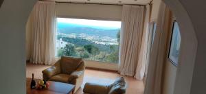 sala de estar con silla y ventana grande en Villa Mas Nou, en Castillo de Aro