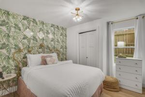 een slaapkamer met een wit bed en een groene en witte muur bij The Beverly in Destin +48 foto's