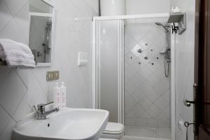 Un baño blanco con lavabo y ducha. en Casa Marisa by Wonderful Italy, en Golfo Aranci 16 fotos más