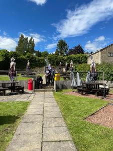 um grupo de pessoas sentadas em mesas de piquenique em um parque em Turks Head Rothbury em Rothbury