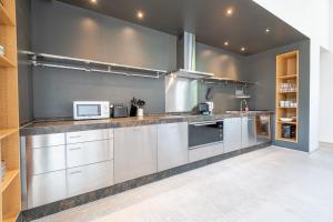 a kitchen with stainless steel cabinets and a microwave at Domaine La Restrie - La Grande Salle des Médicis in Pocé-sur-Cisse