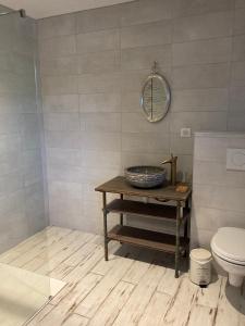 een badkamer met een tafel, een toilet en een spiegel bij Gîte N°2 : YLMADI in Cahors