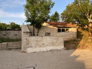 een stenen huis met een raam en een stenen muur bij Gîte N°2 : YLMADI in Cahors