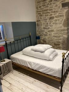 een bed in een kamer met een stenen muur bij Gîte N°2 : YLMADI in Cahors