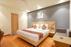 a bedroom with a bed and a desk and a chair at FabHotel JHS Studio in Gurgaon