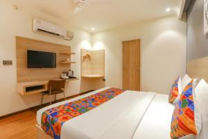 a bedroom with a bed and a desk and a television at FabHotel JHS Studio in Gurgaon