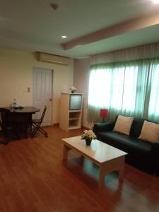 un soggiorno con divano e tavolo di NOP PLACE BANGNA a Ban Bang Phrao