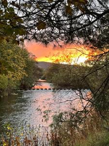 uma vista para um rio com um pôr-do-sol ao fundo em Turks Head Rothbury em Rothbury