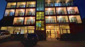 a tall building with lit up windows at night at Victoria Rock Resort in Entebbe