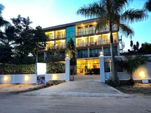 un edificio con una palmera delante de él en Victoria Rock Resort en Entebbe
