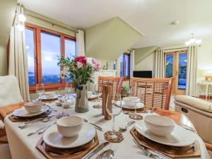 a dining room with a table with plates and silverware at 5 Bed in Loch Tay 86687 in Chesthill