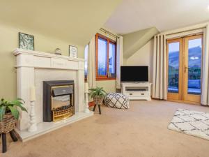 a living room with a fireplace and a television at 5 Bed in Loch Tay 86687 in Chesthill
