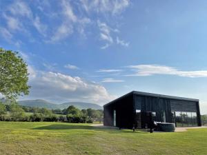 a black house in a field with mountains in the background at 1 Bed in Stokesley 86814 in Great Broughton