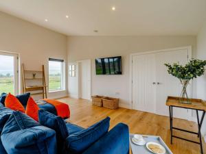 a living room with a blue couch and orange pillows at 1 Bed in Stokesley 86814 in Great Broughton