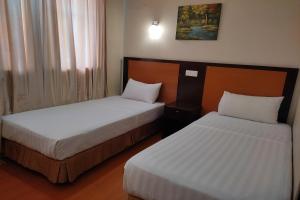 twee bedden in een hotelkamer met bij Hotel D'New 1 KK Sabah in Donggongon
