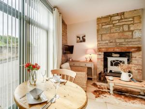 a living room with a table and a fireplace at 1 Bed in Rothbury 88286 in Rothbury