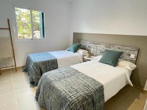 1 dormitorio con 2 camas y ventana en Villa con piscina privada y AC, en Sant Lluis