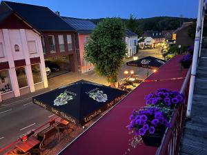 stół z fioletowymi kwiatami na górze ulicy w obiekcie Gasterij Berg en Dal w mieście Slenaken