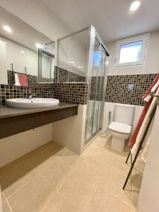 a bathroom with a sink and a shower and a toilet at Villa con piscina privada y AC in Sant Lluis