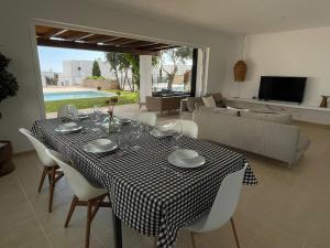 mesa de comedor con mantel a cuadros en blanco y negro en Villa con piscina privada y AC, en Sant Lluis