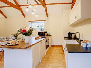 uma cozinha com armários brancos e bancadas pretas em 2 Bed in Barnstaple 88125 em Swimbridge