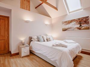 a white bedroom with a bed and a window at 2 Bed in Barnstaple 88125 in Swimbridge