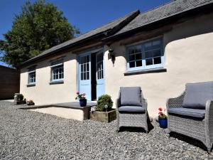 two chairs sitting in front of a house at 2 Bed in Barnstaple 88125 in Swimbridge