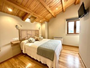 1 dormitorio con 1 cama en una habitación con techos de madera en 29E01 Casa Courego - Vegadeo, en Vegadeo