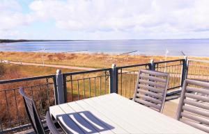 een balkon met een tafel en stoelen en de oceaan bij Baltic View in Glowe